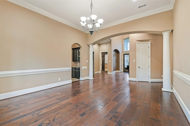 13622 Kluge Corner Ln, Cypress, TX 77429 - empty room featuring arched walkways, a chandelier, crown molding, dark wood-type flooring, and ornate columns