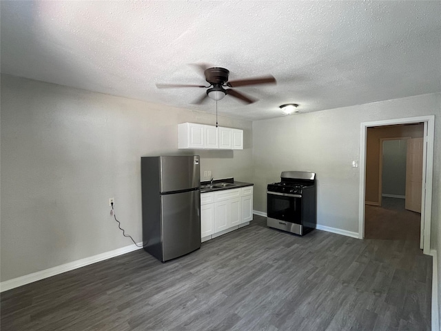 4831 Sycamore Ave Unit 16, Pasadena, TX 77503 - kitchen with appliances with stainless steel finishes, a ceiling fan, dark wood-type flooring, white cabinets, and a textured ceiling