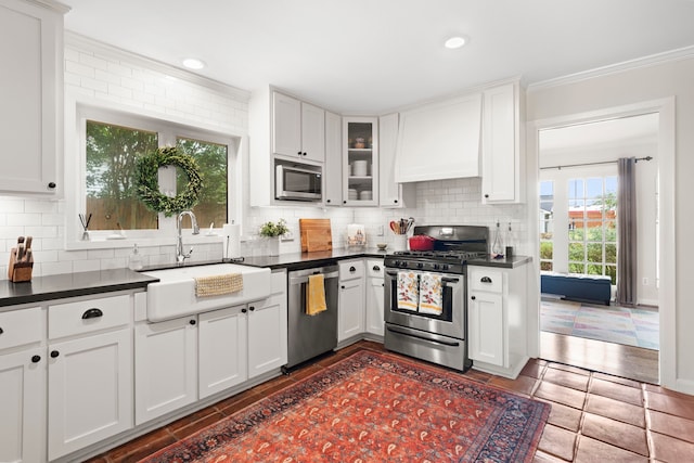 1219 Del Norte St, Houston, TX 77018 - kitchen with appliances with stainless steel finishes, dark countertops, decorative backsplash, white cabinetry, and ornamental molding