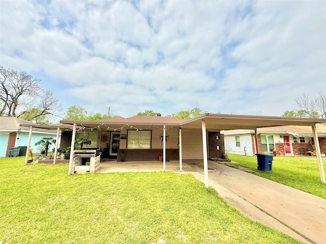 12337 Kayla Ln, Houston, TX 77015 - rear view of house featuring a lawn, driveway, and a carport