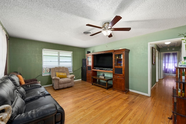 12337 Kayla Ln, Houston, TX 77015 - living room with ceiling fan, a textured ceiling, light wood finished floors, and attic access