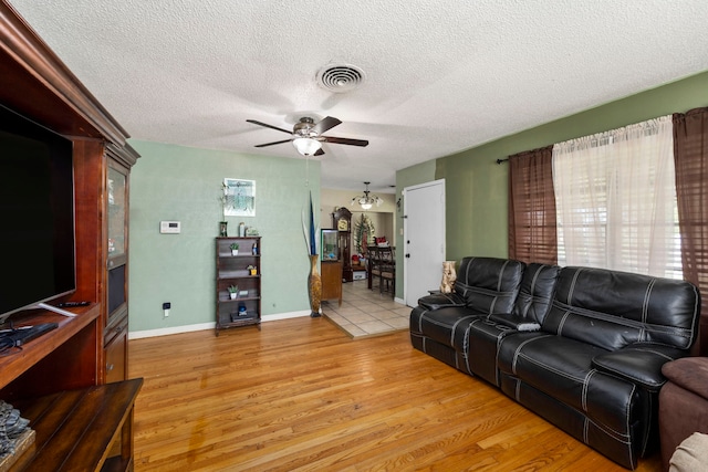 12337 Kayla Ln, Houston, TX 77015 - living room featuring ceiling fan, light wood-style flooring, and a textured ceiling