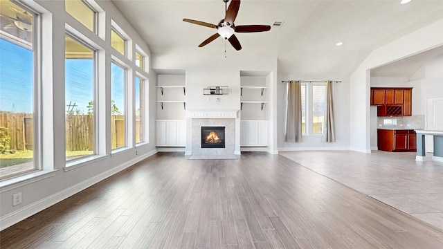 2135 Llerena Ln, League City, TX 77573 - unfurnished living room with a tiled fireplace, a ceiling fan, wood finished floors, lofted ceiling, and built in shelves