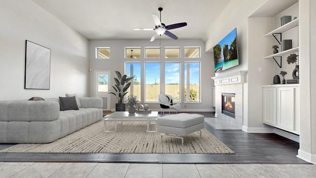 2135 Llerena Ln, League City, TX 77573 - living room featuring a ceiling fan, a tiled fireplace, and wood finished floors