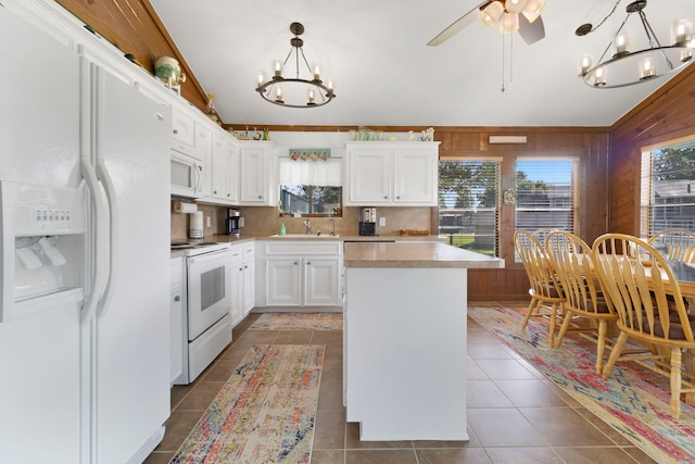 1575 Yaupon Cove Dr, Onalaska, TX 77360 - kitchen featuring white appliances, a chandelier, light countertops, white cabinets, and a center island