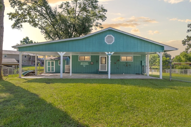 1575 Yaupon Cove Dr, Onalaska, TX 77360 - back of property at dusk with a carport and a storage shed