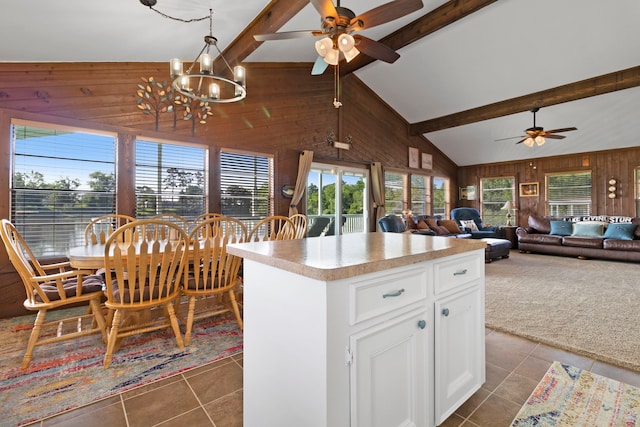 1575 Yaupon Cove Dr, Onalaska, TX 77360 - kitchen featuring wood walls, ceiling fan, dark tile patterned floors, beam ceiling, and a chandelier