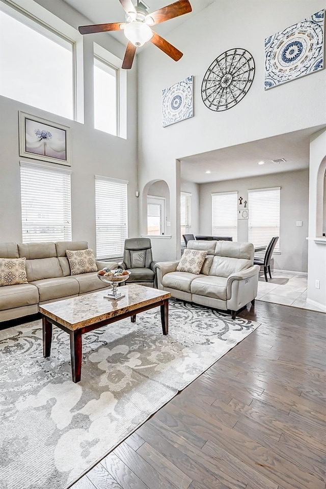 24030 Cannon Anello Ct, Katy, TX 77493 - living room with ceiling fan, plenty of natural light, a high ceiling, wood finished floors, and arched walkways