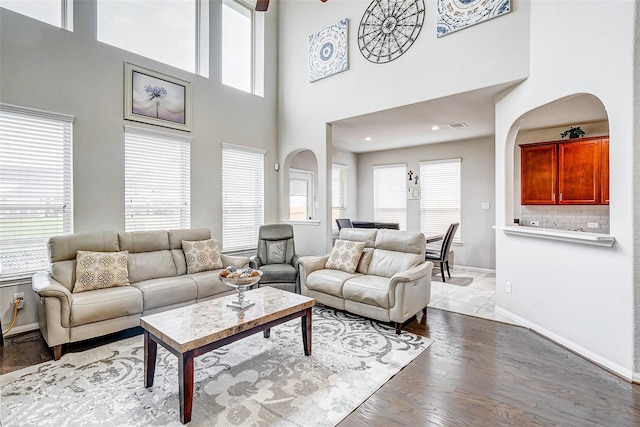 24030 Cannon Anello Ct, Katy, TX 77493 - living area featuring arched walkways, healthy amount of natural light, light wood-type flooring, and a high ceiling