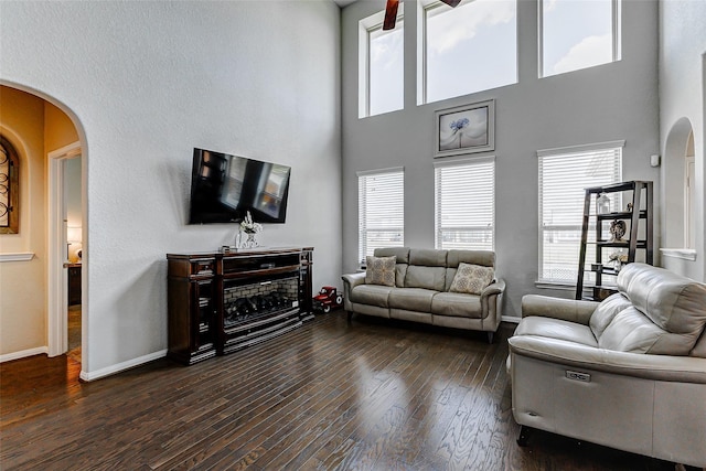 24030 Cannon Anello Ct, Katy, TX 77493 - living room featuring arched walkways, dark wood-style floors, healthy amount of natural light, and a towering ceiling