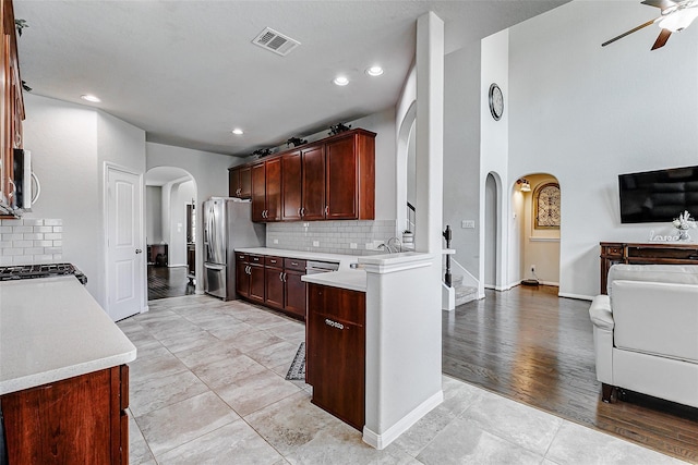 24030 Cannon Anello Ct, Katy, TX 77493 - kitchen featuring arched walkways, open floor plan, stainless steel appliances, ceiling fan, and light countertops