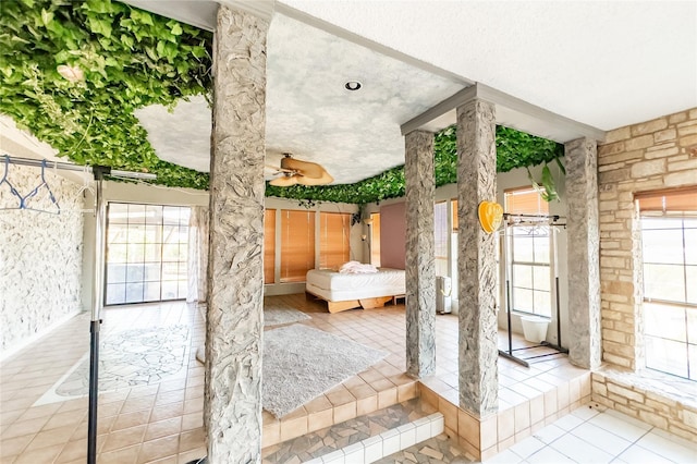 890 Rattlesnake Rd, Harker Heights, TX 76548 - doorway featuring decorative columns, tile patterned flooring, a textured ceiling, and a ceiling fan