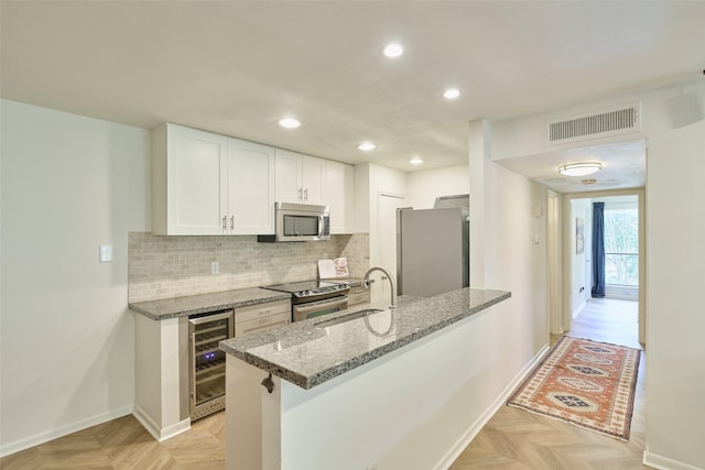 1601 S Shepherd Dr Unit 222, Houston, TX 77019 - kitchen with beverage cooler, appliances with stainless steel finishes, recessed lighting, white cabinets, and light stone counters