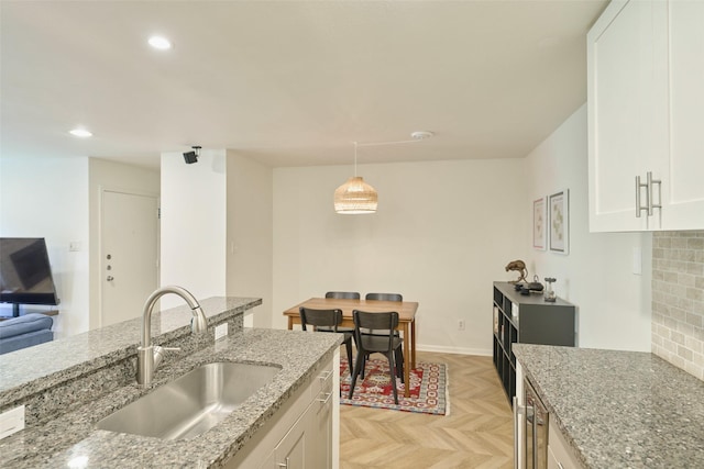 1601 S Shepherd Dr Unit 222, Houston, TX 77019 - kitchen featuring white cabinets, light stone counters, recessed lighting, pendant lighting, and backsplash