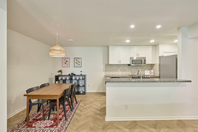 1601 S Shepherd Dr Unit 222, Houston, TX 77019 - kitchen with stainless steel appliances, white cabinetry, light stone counters, recessed lighting, and decorative backsplash