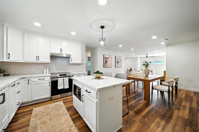 1610 Antoine Dr, Houston, TX 77055 - kitchen featuring stainless steel electric range oven, under cabinet range hood, decorative backsplash, recessed lighting, and white cabinets