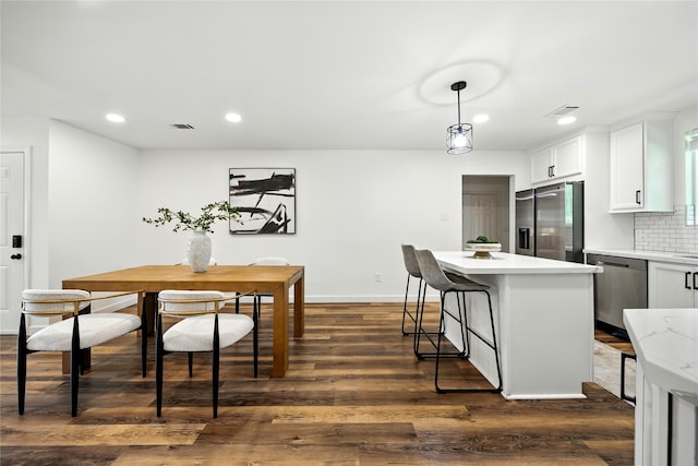 1610 Antoine Dr, Houston, TX 77055 - kitchen with stainless steel appliances, recessed lighting, dark wood-style floors, white cabinets, and backsplash