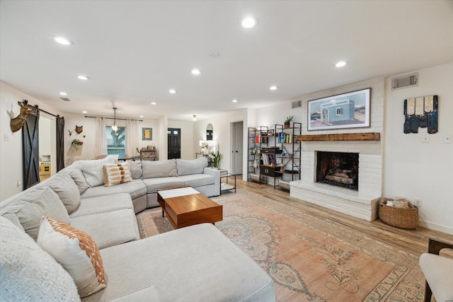 4611 Dunsmere St, Houston, TX 77018 - living room with recessed lighting, a brick fireplace, light wood-style floors, and a barn door