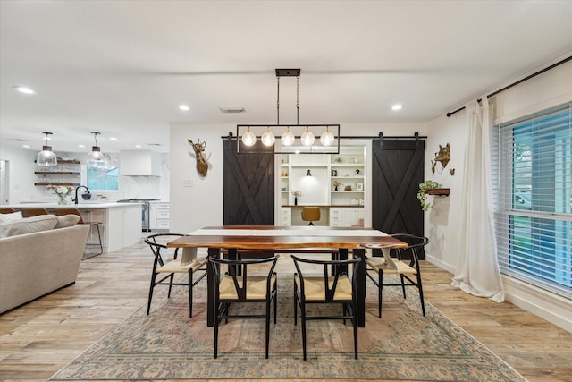 4611 Dunsmere St, Houston, TX 77018 - dining room featuring a barn door, light wood finished floors, and recessed lighting