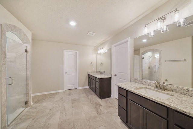 26410 Yaupon Crk, Magnolia, TX 77355 - bathroom featuring a stall shower, two vanities, recessed lighting, and a textured ceiling
