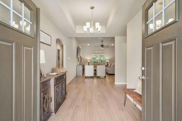 26410 Yaupon Crk, Magnolia, TX 77355 - entryway featuring arched walkways, a tray ceiling, a chandelier, light wood finished floors, and a ceiling fan
