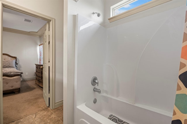1541 3rd St, Hempstead, TX 77445 - bathroom featuring washtub / shower combination, tile patterned floors, and ensuite bathroom