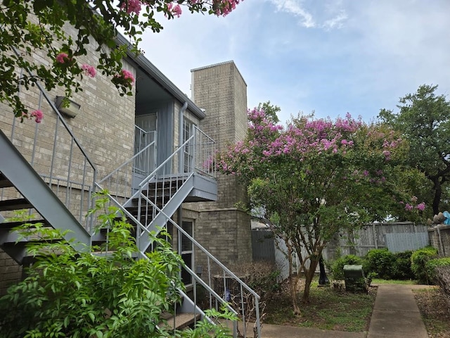7400 Bellerive Dr Unit 1504, Houston, TX 77036 - view of property exterior featuring stairs and a chimney