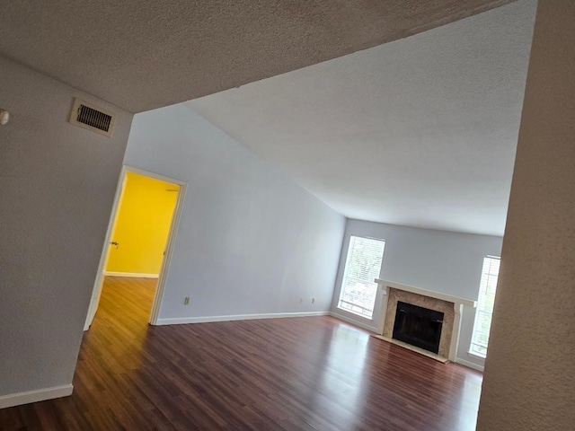 7400 Bellerive Dr Unit 1504, Houston, TX 77036 - unfurnished living room with wood finished floors, a fireplace with flush hearth, and a textured ceiling