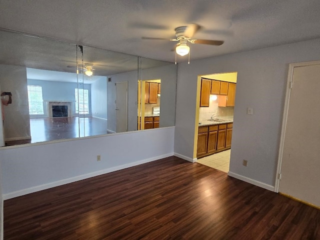 7400 Bellerive Dr Unit 1504, Houston, TX 77036 - empty room featuring wood finished floors, ceiling fan, and a fireplace