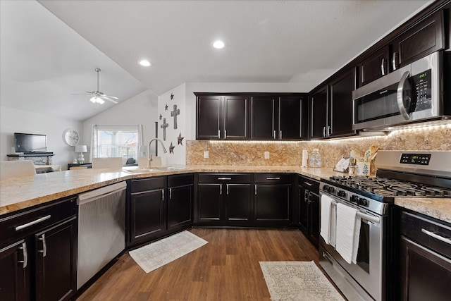 1055 Rancho Grande Dr, Channelview, TX 77530 - kitchen featuring appliances with stainless steel finishes, dark wood finished floors, tasteful backsplash, a ceiling fan, and vaulted ceiling