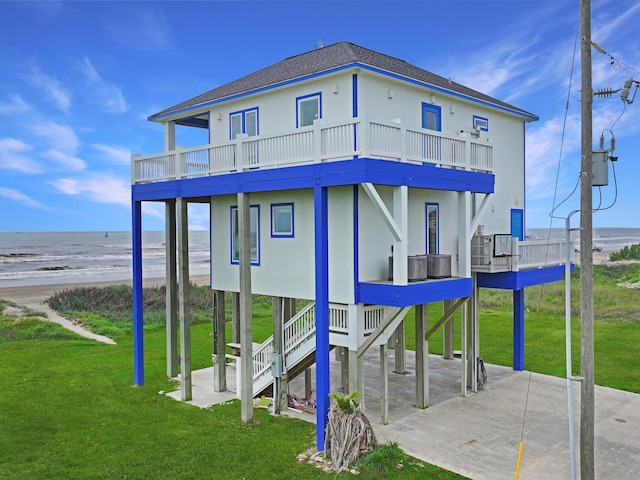 2496 Gilmore, Crystal Beach, TX 77650 - rear view of house with a balcony, a lawn, and stairway