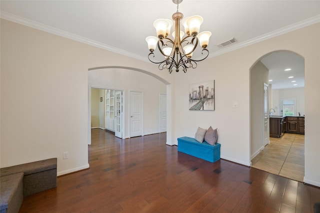 2513 Garnetfield Ln, Friendswood, TX 77546 - unfurnished room with arched walkways, wood finished floors, crown molding, and a chandelier