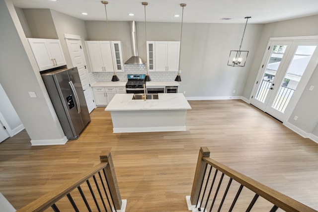 812 Thornton St Unit D, Houston, TX 77018 - kitchen featuring wall chimney exhaust hood, stainless steel appliances, tasteful backsplash, light wood-style floors, and white cabinetry