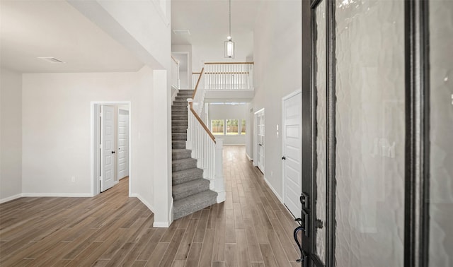 2614 Bisbee Rd, League City, TX 77573 - foyer entrance with stairs, wood finished floors, and a high ceiling