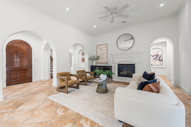 26 N Player Manor Cir, The Woodlands, TX 77382 - living room featuring crown molding, a glass covered fireplace, a ceiling fan, recessed lighting, and arched walkways