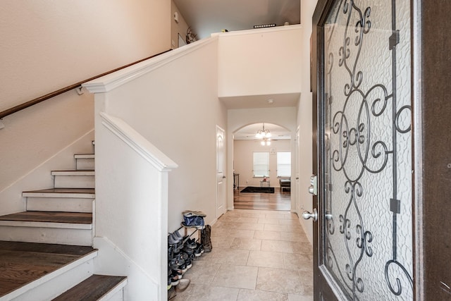 901 Jefferson Ave, Cleveland, TX 77327 - entrance foyer with stairway, arched walkways, light tile patterned floors, and a high ceiling