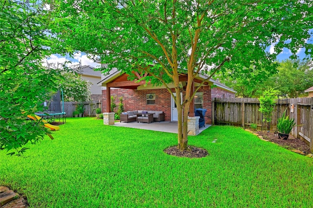 8714 Sunny Gallop Dr, Tomball, TX 77375 - fenced backyard featuring a trampoline, an outdoor hangout area, and a patio