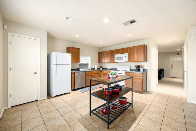 814 Eagles Glide Dr, Houston, TX 77090 - kitchen featuring white appliances, light tile patterned floors, recessed lighting, and brown cabinetry