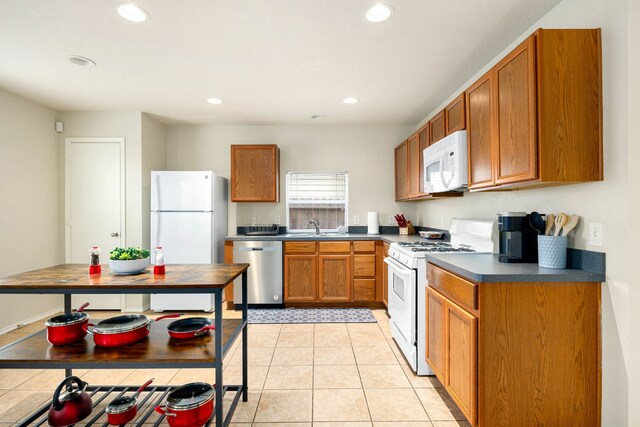 814 Eagles Glide Dr, Houston, TX 77090 - kitchen featuring white appliances, recessed lighting, dark countertops, brown cabinetry, and light tile patterned flooring