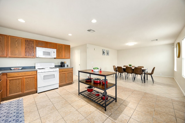 814 Eagles Glide Dr, Houston, TX 77090 - kitchen featuring white appliances, light tile patterned floors, brown cabinetry, and recessed lighting