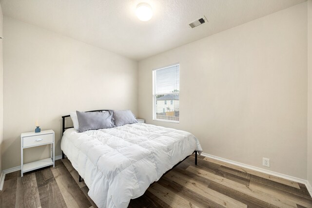 814 Eagles Glide Dr, Houston, TX 77090 - bedroom featuring baseboards and dark wood-style floors