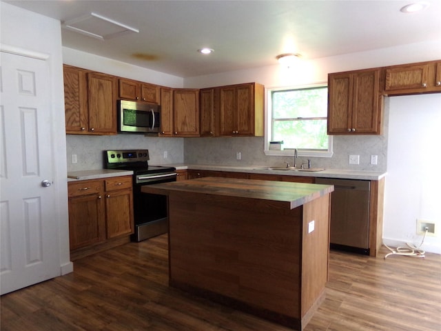 505 S Saint Andrews St, Weimar, TX 78962 - kitchen with stainless steel appliances, brown cabinetry, dark wood-type flooring, decorative backsplash, and recessed lighting