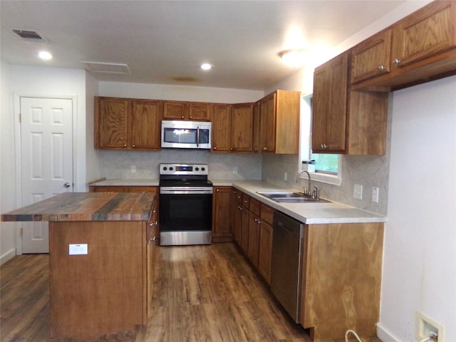 505 S Saint Andrews St, Weimar, TX 78962 - kitchen featuring appliances with stainless steel finishes, dark wood-type flooring, wood counters, a center island, and brown cabinetry