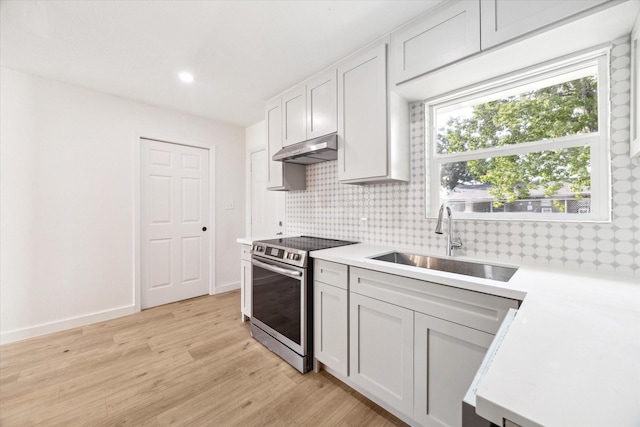 5859 Belmark St, Houston, TX 77033 - kitchen with stainless steel electric range, under cabinet range hood, backsplash, light countertops, and recessed lighting