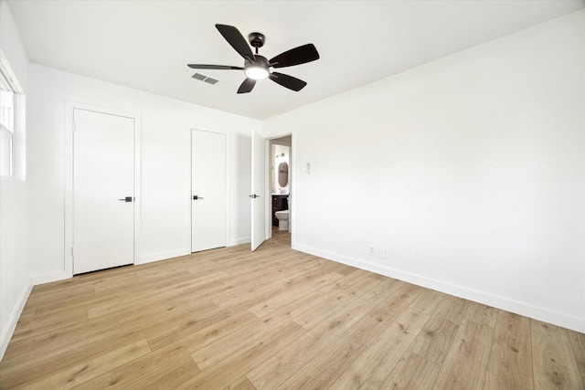 5859 Belmark St, Houston, TX 77033 - unfurnished bedroom featuring light wood finished floors, two closets, ceiling fan, and ensuite bathroom