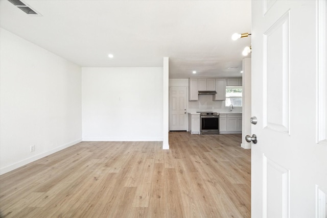 5859 Belmark St, Houston, TX 77033 - unfurnished living room featuring light wood-type flooring and recessed lighting