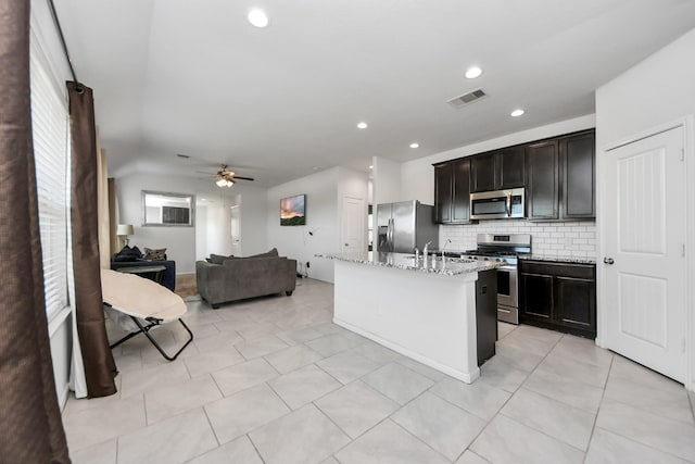 1404 Woods Lake Ct, Houston, TX 77047 - kitchen featuring stainless steel appliances, decorative backsplash, open floor plan, ceiling fan, and an island with sink