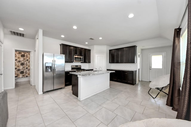1404 Woods Lake Ct, Houston, TX 77047 - kitchen with appliances with stainless steel finishes, tasteful backsplash, light stone countertops, a kitchen island with sink, and recessed lighting