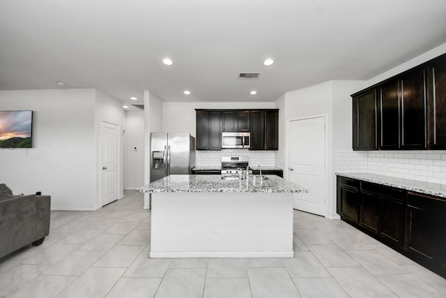 1404 Woods Lake Ct, Houston, TX 77047 - kitchen with stainless steel appliances, light stone countertops, backsplash, a kitchen island with sink, and recessed lighting