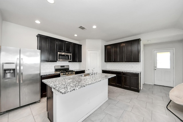 1404 Woods Lake Ct, Houston, TX 77047 - kitchen featuring stainless steel appliances, light stone countertops, tasteful backsplash, recessed lighting, and a kitchen island with sink
